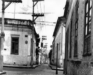 O último beco do Centro de Taubaté, que conectava a Rua Visconde do Rio Branco à Rua Dr. Souza Alves. A casa de esquina, à esquerda, pertenceu ao casal Cesídio e Lygia Ambrogi, à direita é a Casa Oliveira Costa e no primeiro plano, à direita, a Farmácia São José.